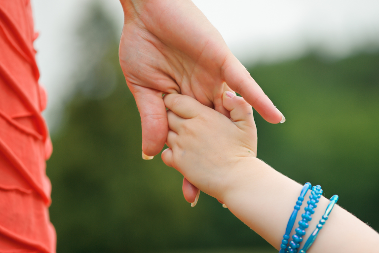 母と子どもが手をつないでいる様子。